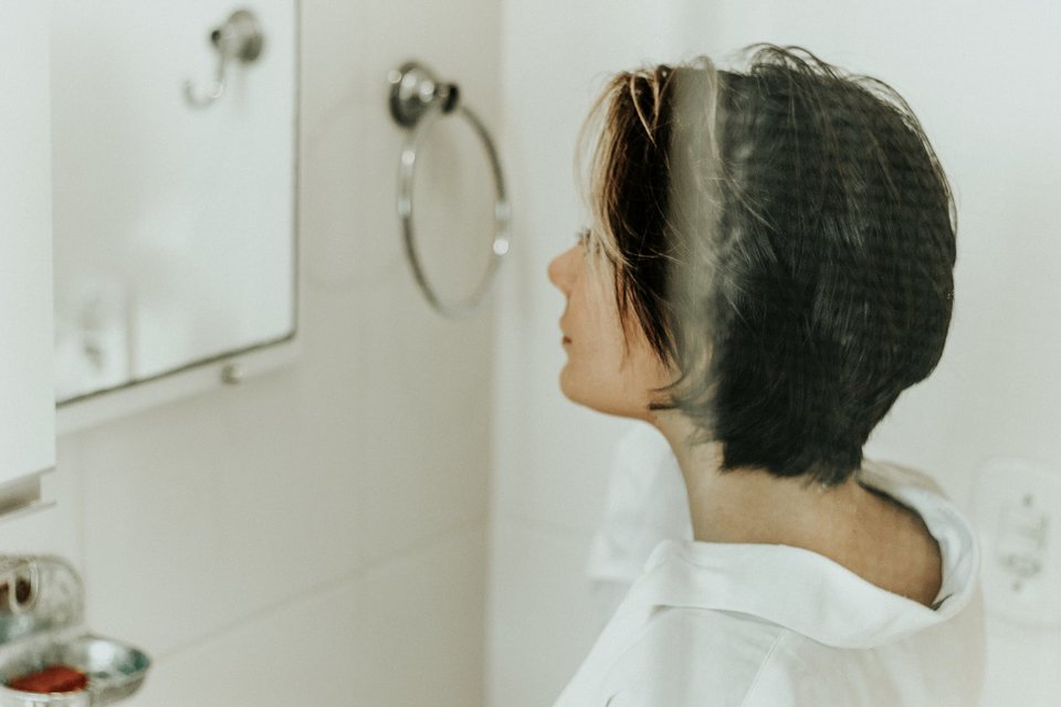 woman looking at mirror